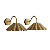 Front angled view of a matching pair of handcrafted brass pleated dome wall sconces with elegant curved wall arms.