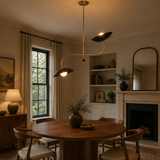 Strasbourg 2 light black disc chandelier installed above a round dining table in a warm Mid-Century Modern dining room.