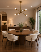 Strasbourg 6 light antique brass Sputnik chandelier centered above a round wood dining table in a warm modern dining room.
