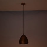 Sutton hammered bell pendant light casting a soft warm ambient glow while suspended from an adjustable black cord.