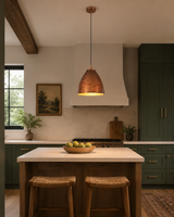 Sutton hammered bell pendant light installed above a modern kitchen island, adding warm lighting and rustic industrial elegance to the space.