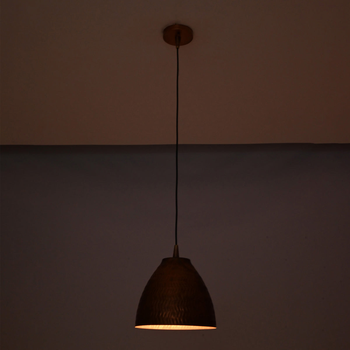 Close-up detail of the handcrafted hammered copper bell shade featuring an artisan textured finish and elegant curved silhouette.