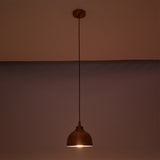 Sutton hammered copper mini dome pendant light casting a warm focused glow with textured copper shade in a dark setting.