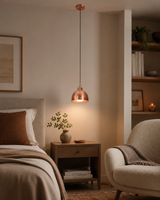 Sutton hammered copper mini dome pendant light installed beside a modern bedroom, providing warm ambient lighting with handcrafted copper elegance.