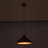 Sutton hammered copper dome pendant light casting focused downward illumination with a warm interior glow.