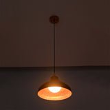 Detailed view of Sutton hammered copper pendant light with illuminated globe bulb and textured handcrafted dome shade.