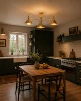 Sutton 3 light brass linear cone chandelier installed above a dining table in a warm modern kitchen interior