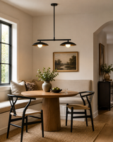 Sutton 2-light linear dome pendant chandelier installed above a modern dining table, providing warm ambient lighting in a contemporary breakfast nook.