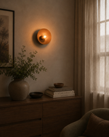 Sutton Modern Dome Wall Sconce installed on a contemporary bedroom wall, providing warm ambient lighting above a wooden console with modern décor.