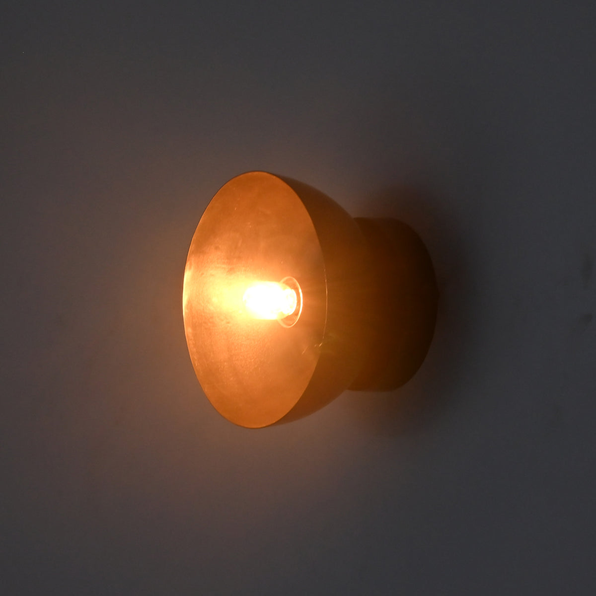 Side illuminated view of the Sutton Modern Dome Wall Sconce highlighting the sculptural dome profile and warm accent lighting.