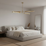 Taormina 4 light brass-tone linear chandelier shown from the front with four elongated shades arranged across two horizontal levels.