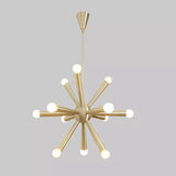 Front view of the Tokyo 12-light Mid-Century Modern Sputnik chandelier featuring a brass-tone finish, elongated tapered metal arms, white globe bulbs, and a central spherical hub.