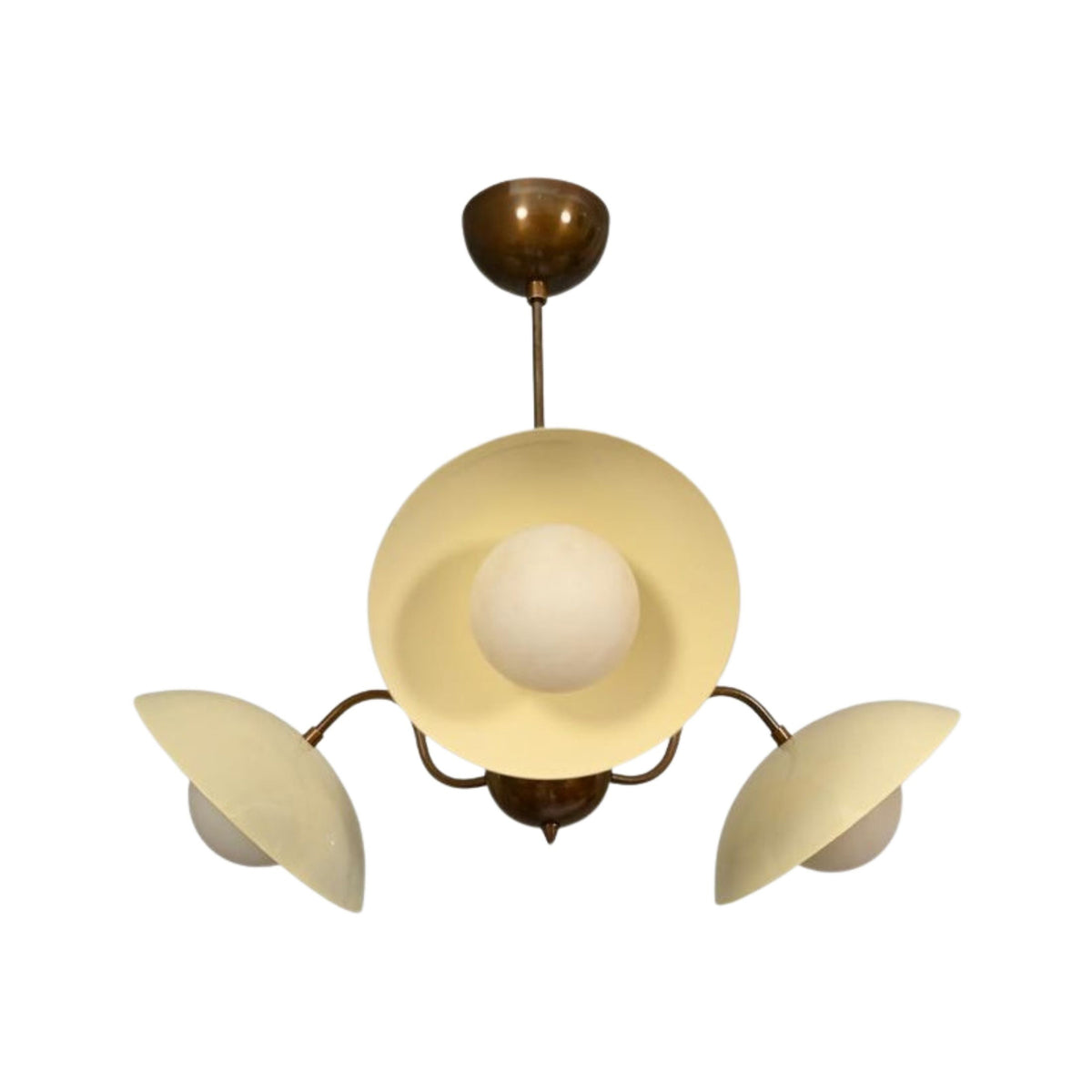 Toledo 3 light Mid-Century chandelier shown from an angled view with cream hat shades, white globe diffusers, and curved aged brass arms.