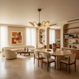 Toledo 3 light chandelier featuring cream hat-shaped shades, opal globe diffusers, and aged brass curved arms shown from the front.