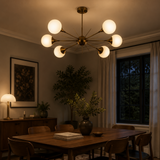 Toledo 6 light Mid-Century Modern globe chandelier illuminated above a warm contemporary dining room table.