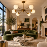 Toledo 6 light brass-tone Sputnik chandelier with illuminated opal globe shades installed in a sophisticated modern living room.