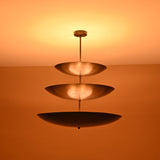 Close-up of illuminated triple bowl chandelier in blackened brass finish, showcasing soft indirect light