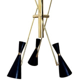 Close-up view of the Turin 3-light Mid-Century Modern chandelier featuring matte-black double-cone shades, brass-tone accents, slender angular arms, and a sculptural central metal structure.