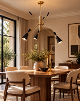 Turin 3-light sculptural cone chandelier hanging above a walnut dining table with cream upholstered chairs, creating warm ambient lighting in a sophisticated Mid-Century Modern dining room.