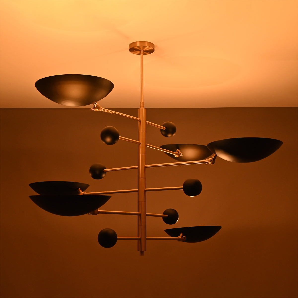 Turin Disc Balance Chandelier close ceiling view showing black disc shades, gold-tone frame, and warm light effect.