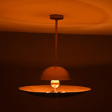 Venice Disc pendant shown illuminated, casting a warm glow through its sculptural layered shade profile.