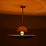 Venice Disc pendant glowing warmly above a dining table, highlighting its layered double-disc shade design.