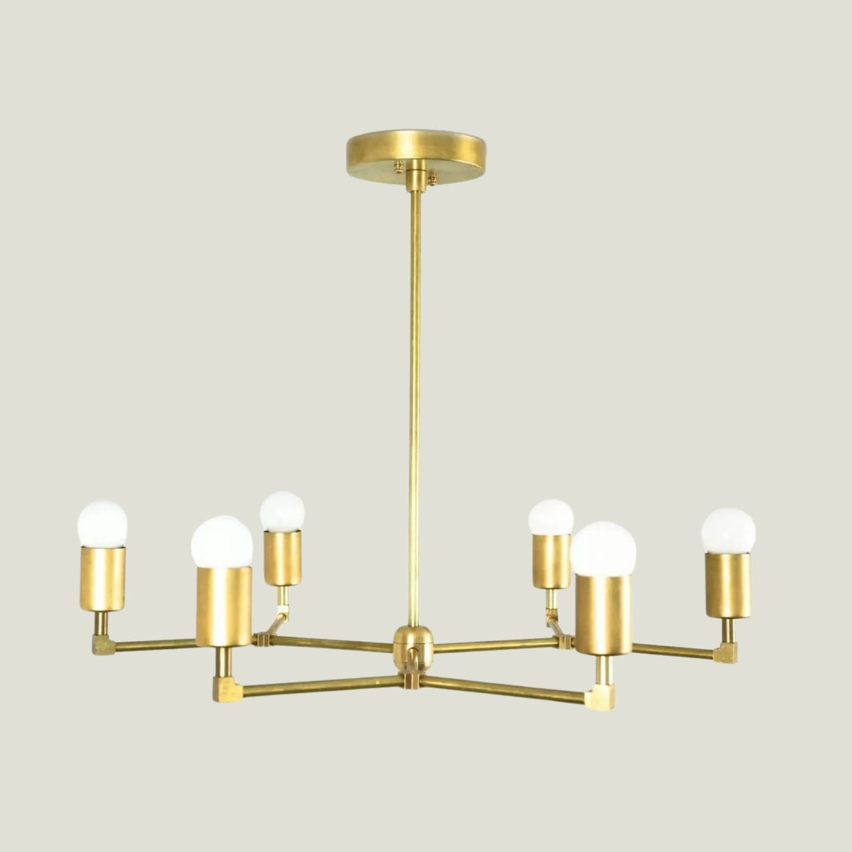 Venice 6 light brass-tone chandelier shown from the front highlighting its open geometric arms and exposed bulb design.