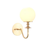 Verona Modern Globe Glass Wall Sconce illuminated with frosted opal globe and elegant curved brass arm shown from an angled front view.