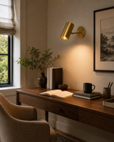 Verona Adjustable Cylinder Wall Sconce installed above a modern wooden desk, providing warm directional reading light in a contemporary home office.