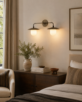 Verona dual dome vanity wall light installed above a bedroom console, providing warm ambient illumination with handcrafted bronze dome shades and opal glass globes.