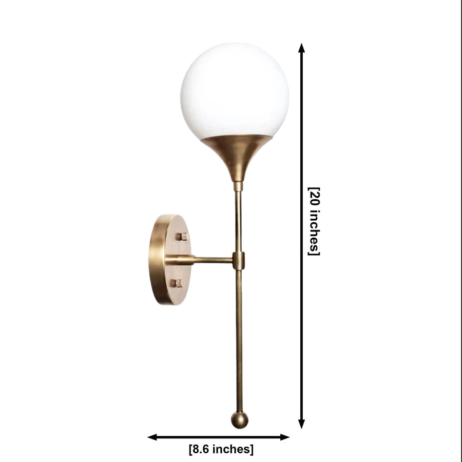 Verona globe balance wall sconce with antique brass finish and illuminated glass globe styled in an elegant living room.