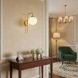 Verona Mid-Century Modern brass globe wall sconce with warm illuminated glass shade – Model 32808