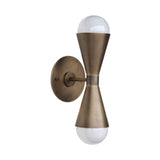 Illuminated Verona hourglass globe wall sconce in antique brass finish showcasing warm ambient up-and-down lighting with exposed globe bulbs.