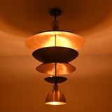 Illuminated close-up of the Verona Layered Disc Pendant Chandelier displaying the warm brass interior and softly diffused ambient lighting.