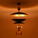 Night view of the Verona Layered Disc Pendant Chandelier with layered metal shades producing a warm, inviting ambient glow.