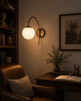 Verona Modern Globe Glass Wall Sconce installed in a cozy study, providing warm ambient illumination above a wooden desk and reading chair.