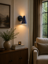 Verona perforated cone wall sconce installed in a living room with warm decorative and downward lighting, Model 32792.