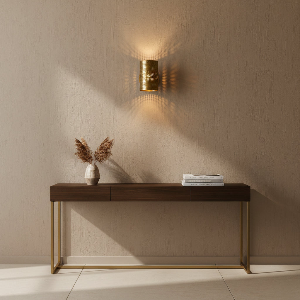Angled view of Verona perforated cylinder wall sconce with round brass wall canopy and warm light, Model 32783.