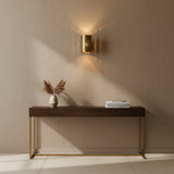 Angled view of Verona perforated cylinder wall sconce with round brass wall canopy and warm light, Model 32783.