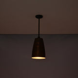 Night view of the Verona ribbed bell pendant light suspended from the ceiling with warm focused illumination and handcrafted ribbed copper shade.