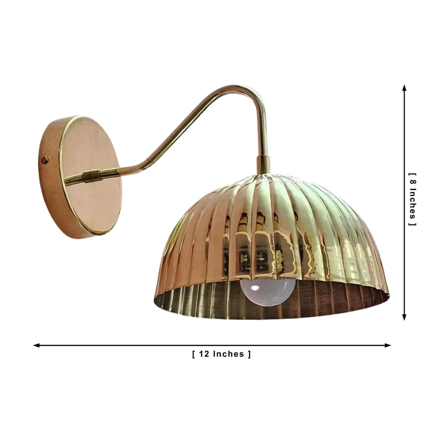 Verona ribbed brass dome wall sconce illuminated above a bathroom vanity with warm ambient lighting.