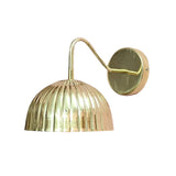 Side angled view of Verona brass wall sconce with fluted dome shade, curved arm and round wall canopy.
