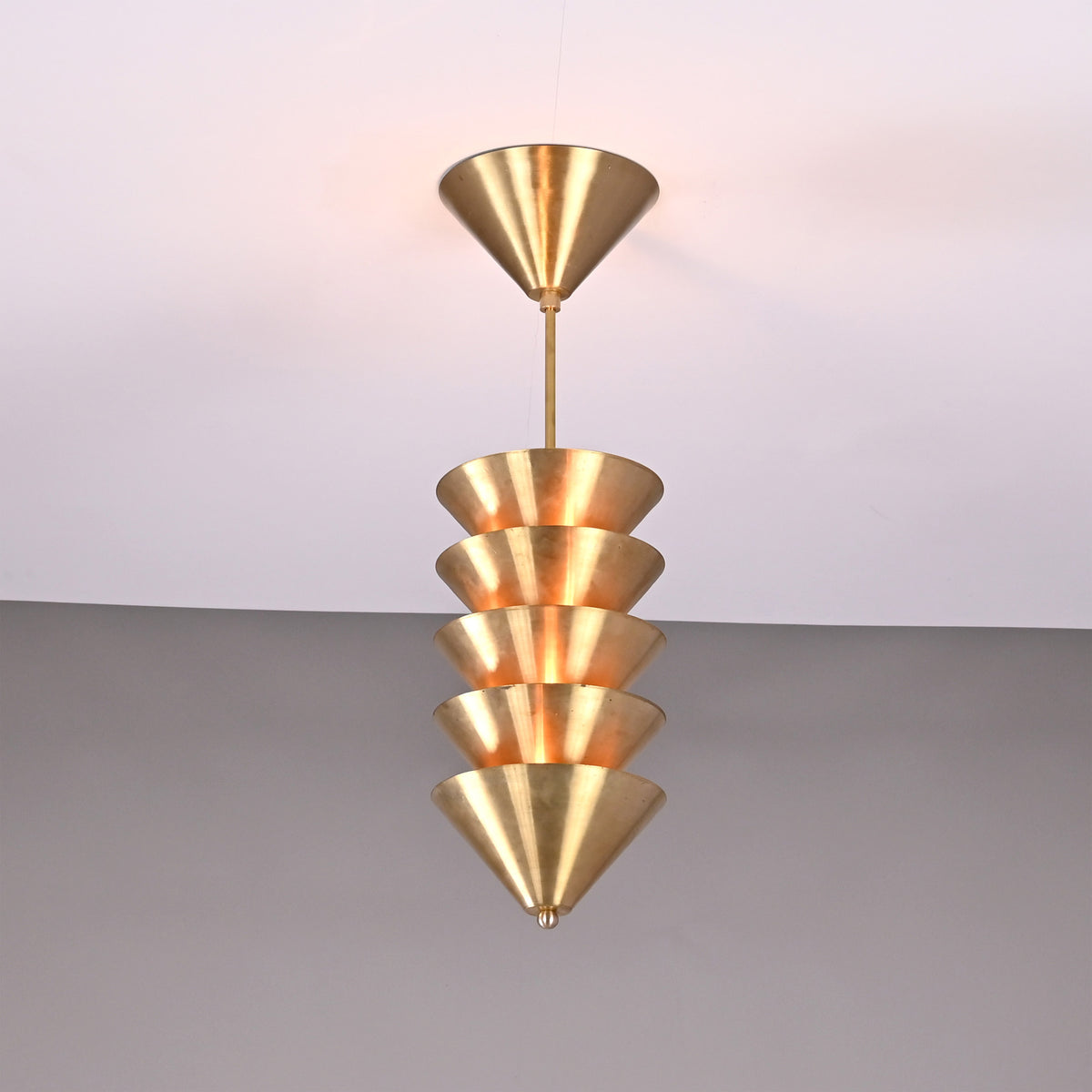 Verona Stacked Cone Pendant installed on ceiling with warm glow and tiered cone shade design.