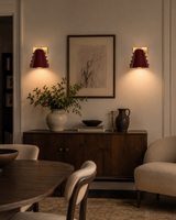 Pair of Verona Studded Cone Wall Sconces installed in a modern living room, providing warm ambient lighting above a wooden console in a contemporary interior.