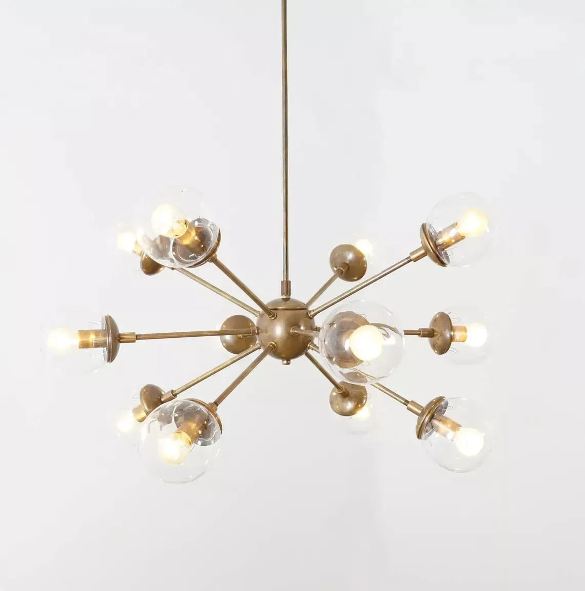 Angled view of the Versailles 12 light brass-tone Sputnik chandelier with multidirectional arms and clear glass globes.