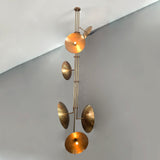 Luxury vertical brass chandelier highlighting brushed metal texture and balanced disc arrangement.