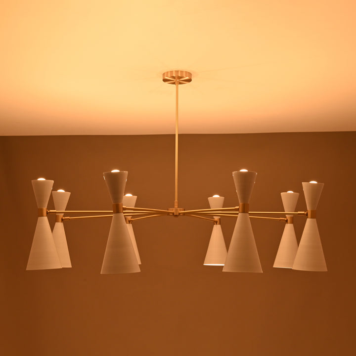 Contemporary brass chandelier illuminated in a warm setting, featuring 16 white cone shades casting soft ambient light