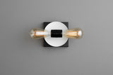 Modern wall light with white round disc backplate and black square base, twin horizontal Edison bulbs, minimalist contemporary sconce.