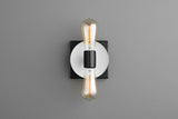 Minimal wall sconce with white round disc on black square plate and two vertical Edison filament bulbs, modern industrial wall lighting.
