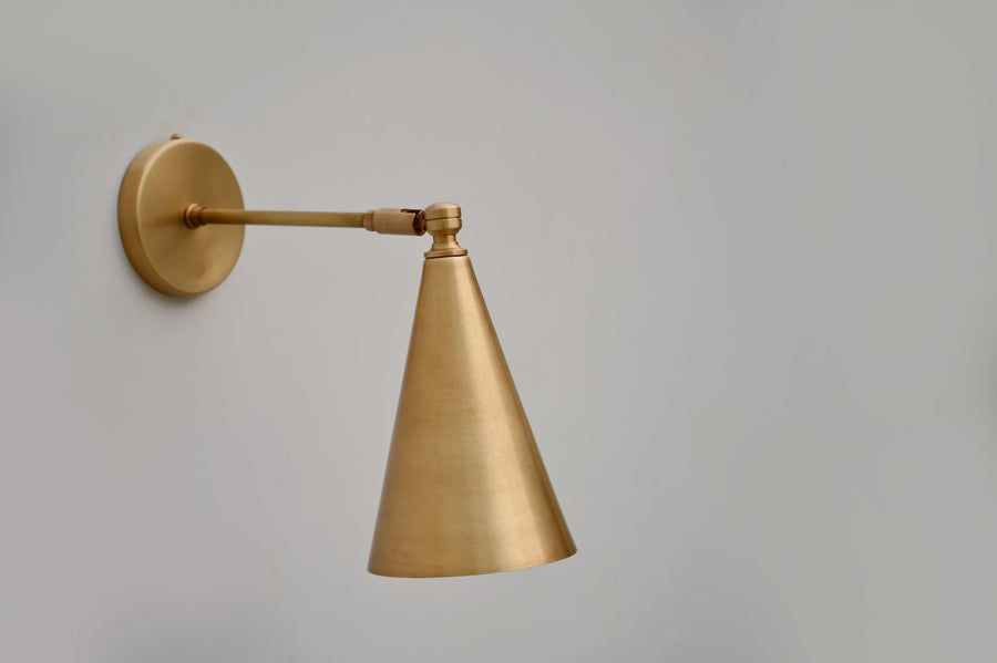 Adjustable brass cone wall light with brushed satin finish and minimalist design, handcrafted by Brass Leaf Studio.